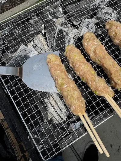 網にくっついたつくねをステンレス製のフライ返しで動かす